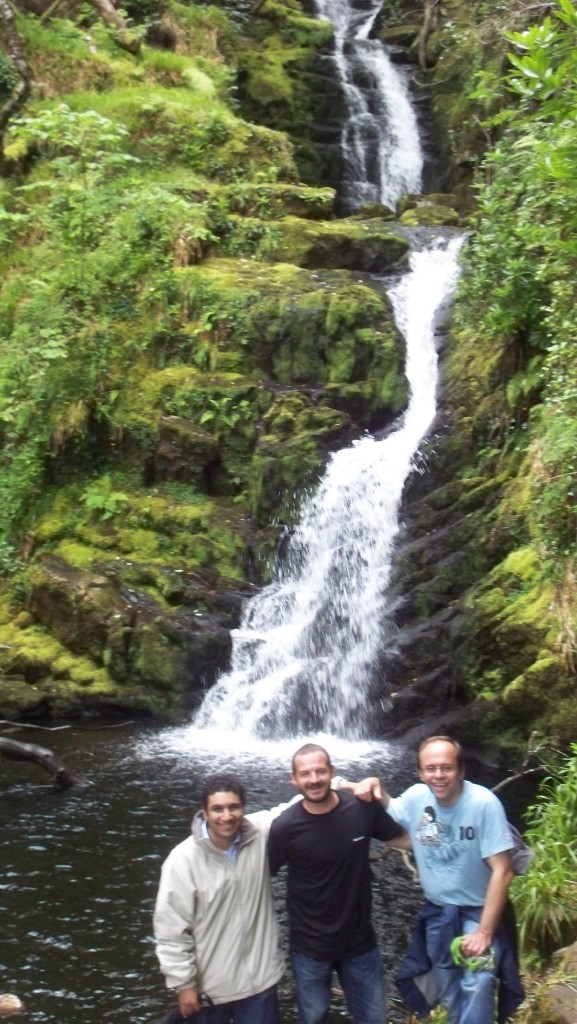 students smile and pose below beautiful waterfall in rural ireland
