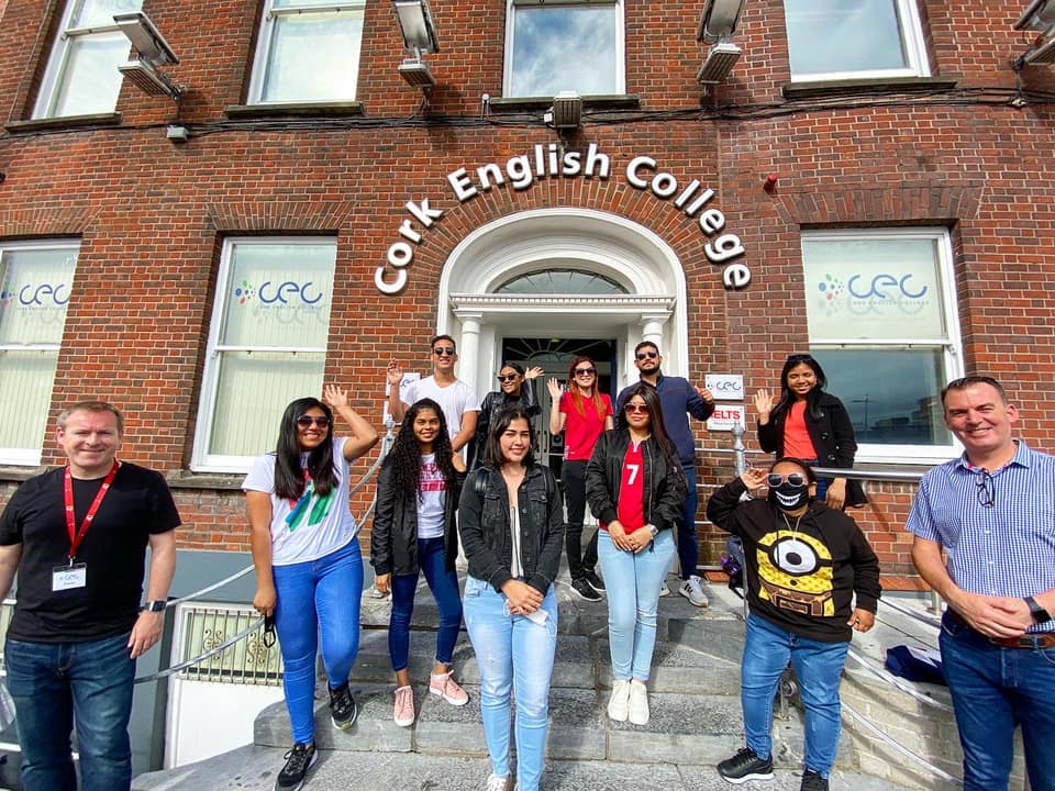 students smiling waving outside cork english college