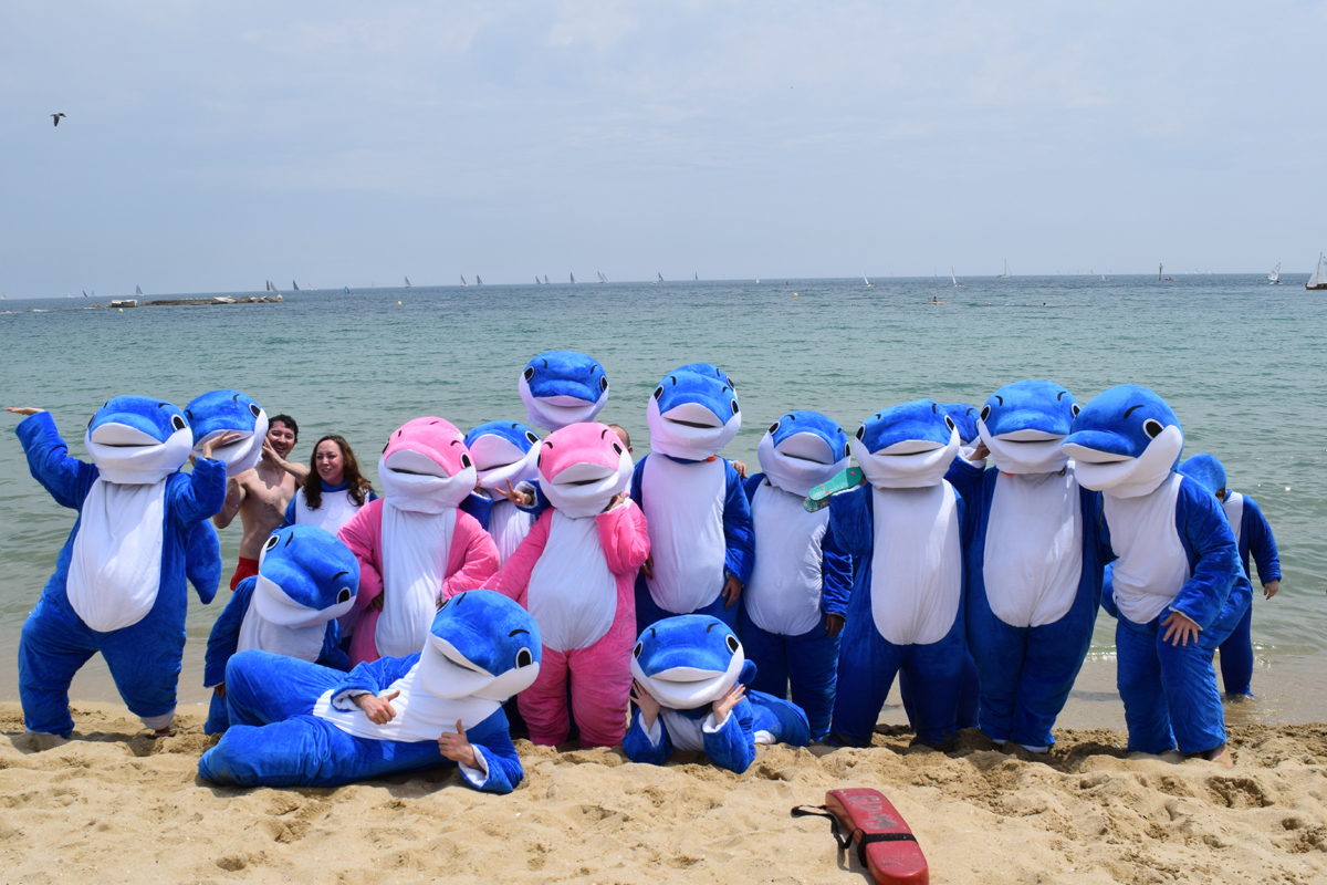 students dressed up as delfin school dolphin mascot on the beach